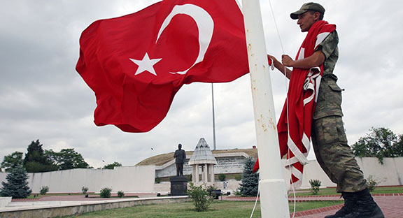 Serviceman raising Turkish flag (Photo: AP Photo/Burhan Ozbilici)