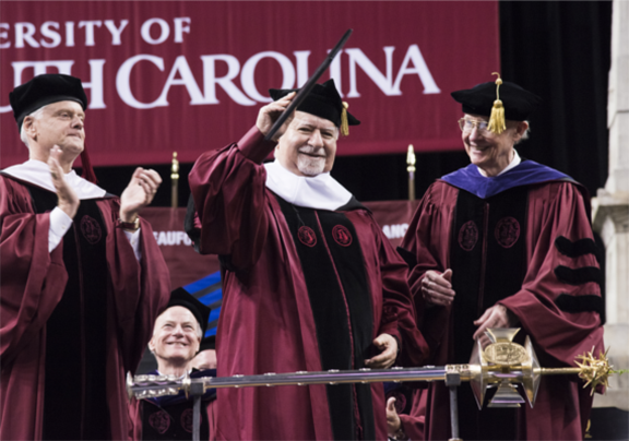 Vartan Gregorian waves to the audience after receiving an honorary doctoral degree at the University of South Carolina commencement exercises where he shared the stage with J. Cantey Heath, Jr., Secretary to the Board of Trustees and University Secretary; and The Hon. John C. von Lehe, Jr., Chairman of the Board of Trustees. (Photo: USC/Jason Ayer)