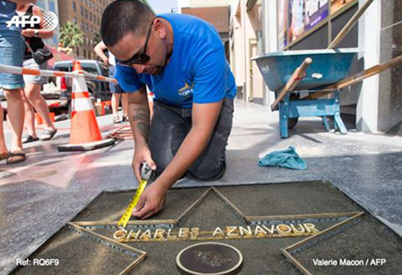 A worker lays concrete ahead of placing Charles Aznavour's star