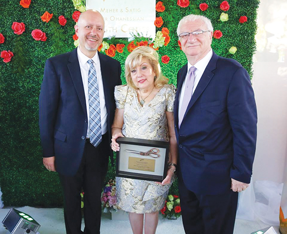 ARF Zavarian Gomideh chairman Mike Kelechian presents the scissors used to cut the ribbon to Meher and Satig Der Ohanessian