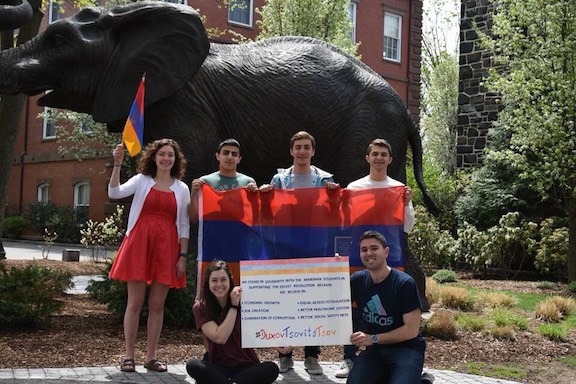 A group of students pose with signs in support of Armenia's popular movement