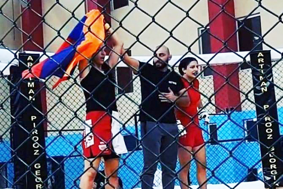 Armenia's Karine Karapetyan (left) waves the Armenian flag after beating Azerbaijan's Rena Safarova, the sister of ax-murderer Ramil Safarov
