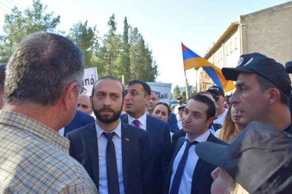 Parliament Speaker Ararat Mirzoyan and lawmaker Mkhitary Hayrapetyan are confronted by angry protesters in front of the Melkonian School on July 5