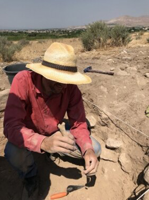 Dr. Cobb excavates and examines a bone. Photo Credit: Yadian Wang