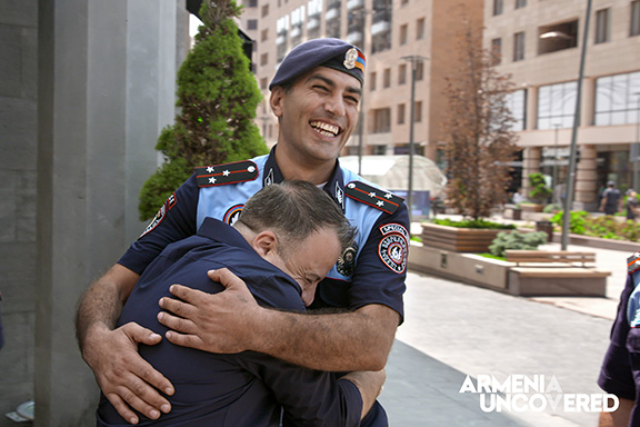 Kev Orkian embracing an Armenian police officer