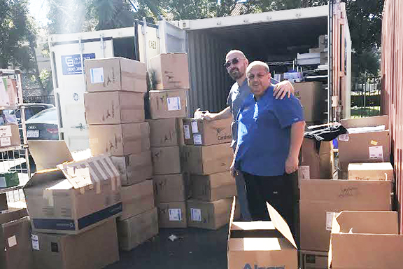 CCSC Administrator Raffi Sarkissian and surgery technician Vardan Lalayan reviewing boxes of supplies bound for Armenia in response to the COVID-19 containment efforts