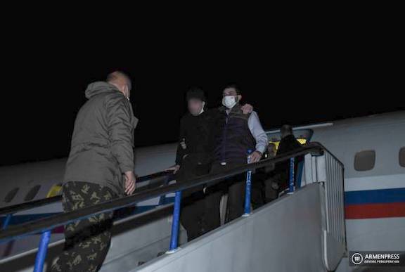 One of the five Armenian prisoners of war is being escorted off a plane that landed at Erebuni Airport on Jan. 28